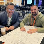 Terry Munoz of Campground Consulting Group reviewing a campground site plan with a colleague at an industry conference